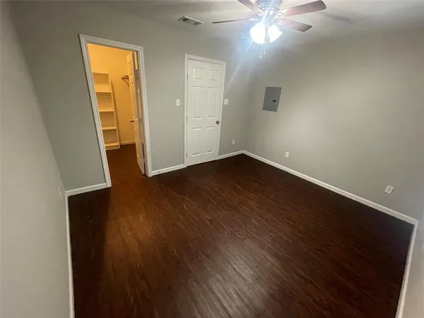 an empty room with wooden floor and closet