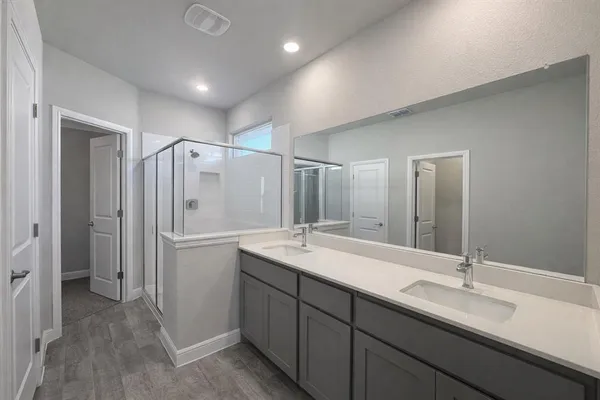 a bathroom with a shower sink vanity granite and a mirror