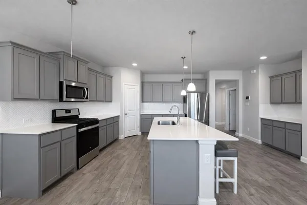 a large kitchen with kitchen island a sink a counter space stainless steel appliances and cabinets