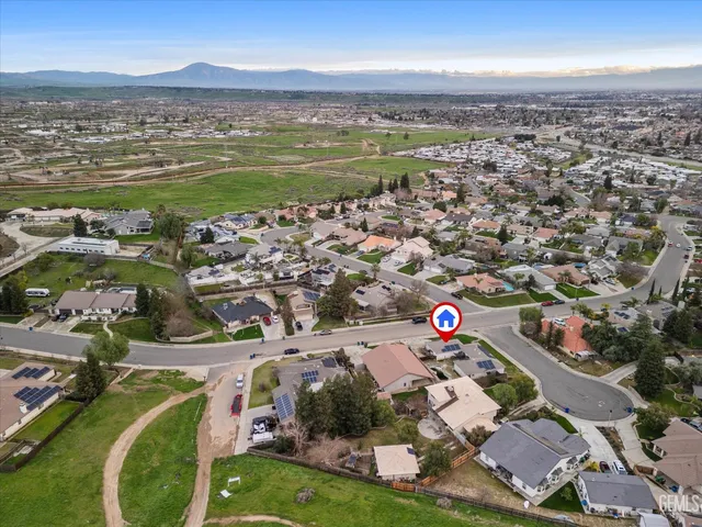 an aerial view of a city with lots of residential buildings ocean and mountain view in back
