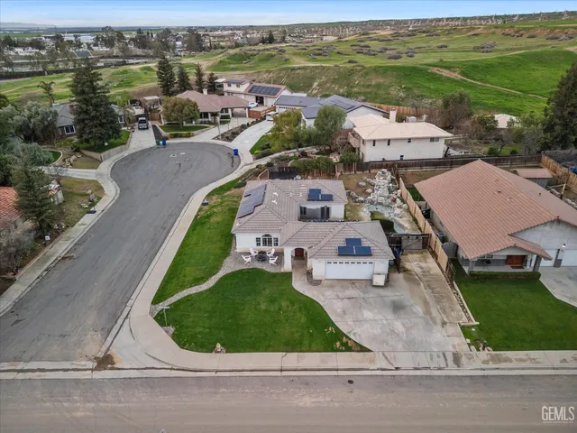 an aerial view of residential houses with outdoor space and parking