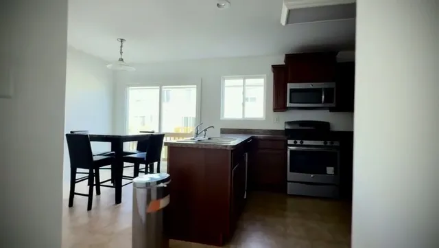 a kitchen with stainless steel appliances granite countertop a stove and a microwave