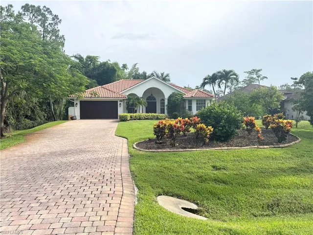 a view of a house with a yard and potted plants