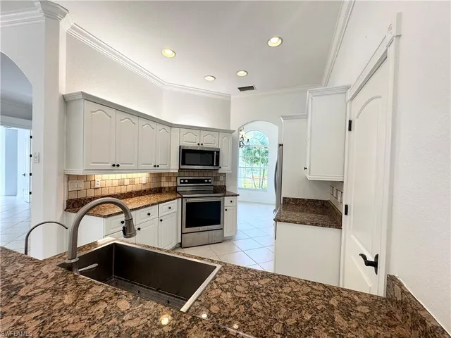 a kitchen with stainless steel appliances granite countertop a sink stove and cabinets