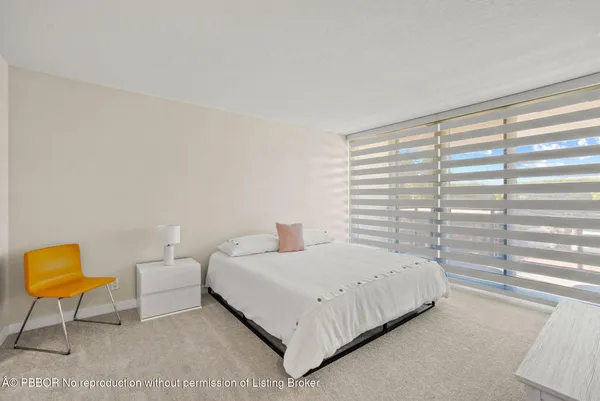 a bedroom with a bed a chair and a window