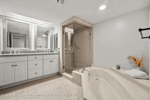 a spacious bathroom with a double vanity sink mirror and bathtub