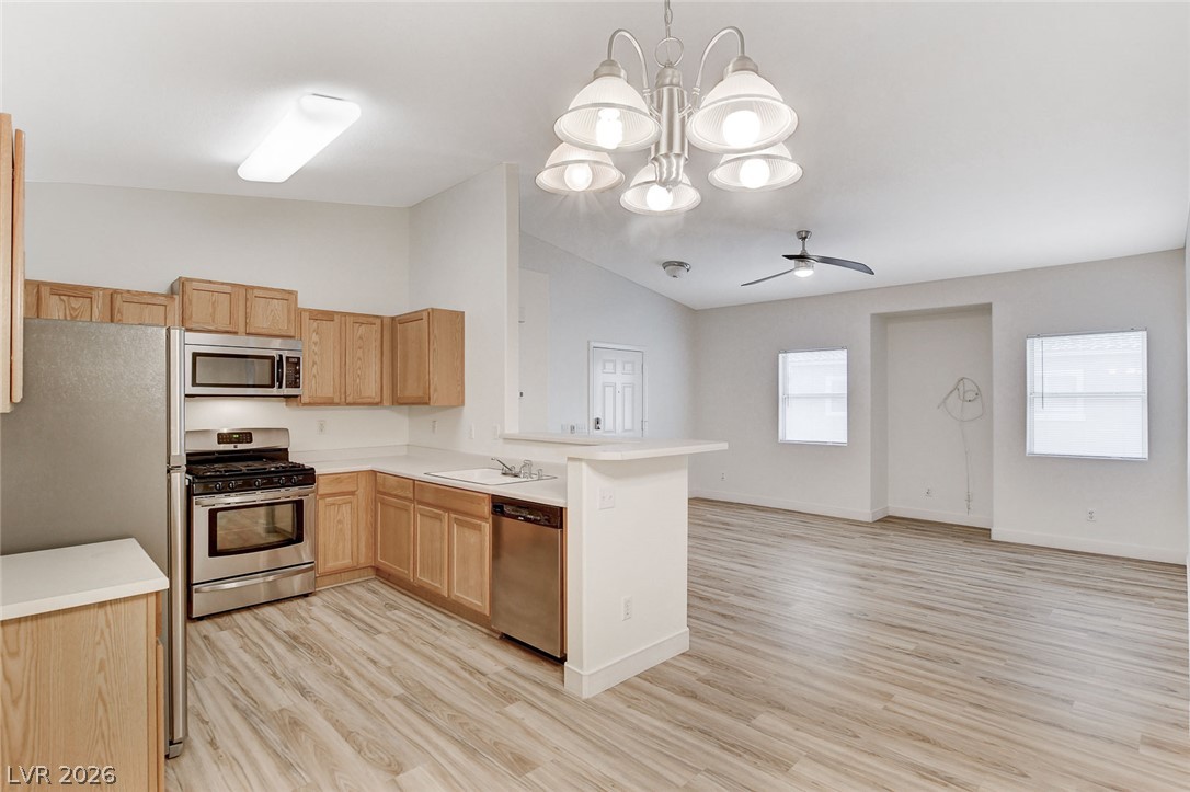 2052 Quarry Ridge Street, Unit 201 Las Vegas, NV 89117 - Photo 7 of 25 An open-concept living space integrates a well-appointed kitchen with stainless steel appliances and light wood flooring.