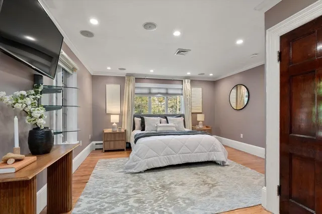 a spacious bedroom with a large bed and a chandelier