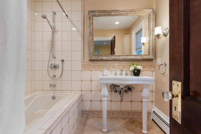 a bathroom with a bathtub sink and mirror