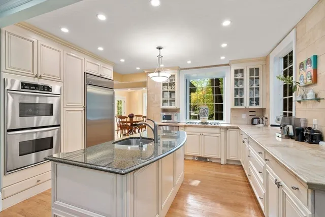 a kitchen with kitchen island granite countertop a sink stove and refrigerator