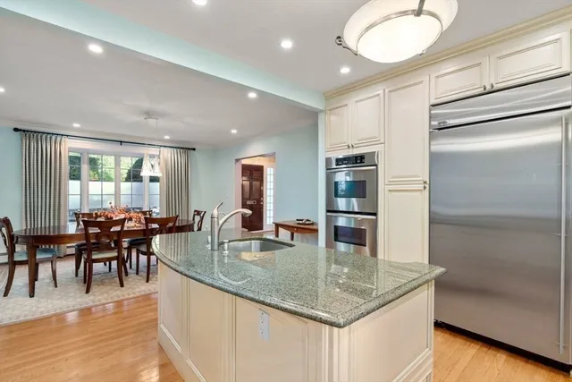 a dining hall with stainless steel appliances granite countertop a granite counter tops and a view of living room