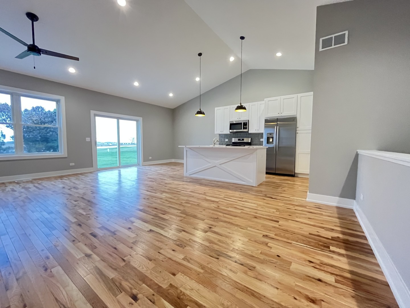 519 Cobblestone Circle Harvard, IL 60033 - Photo 2 of 19 a large kitchen with stainless steel appliances a large counter top a wooden floor and a large window