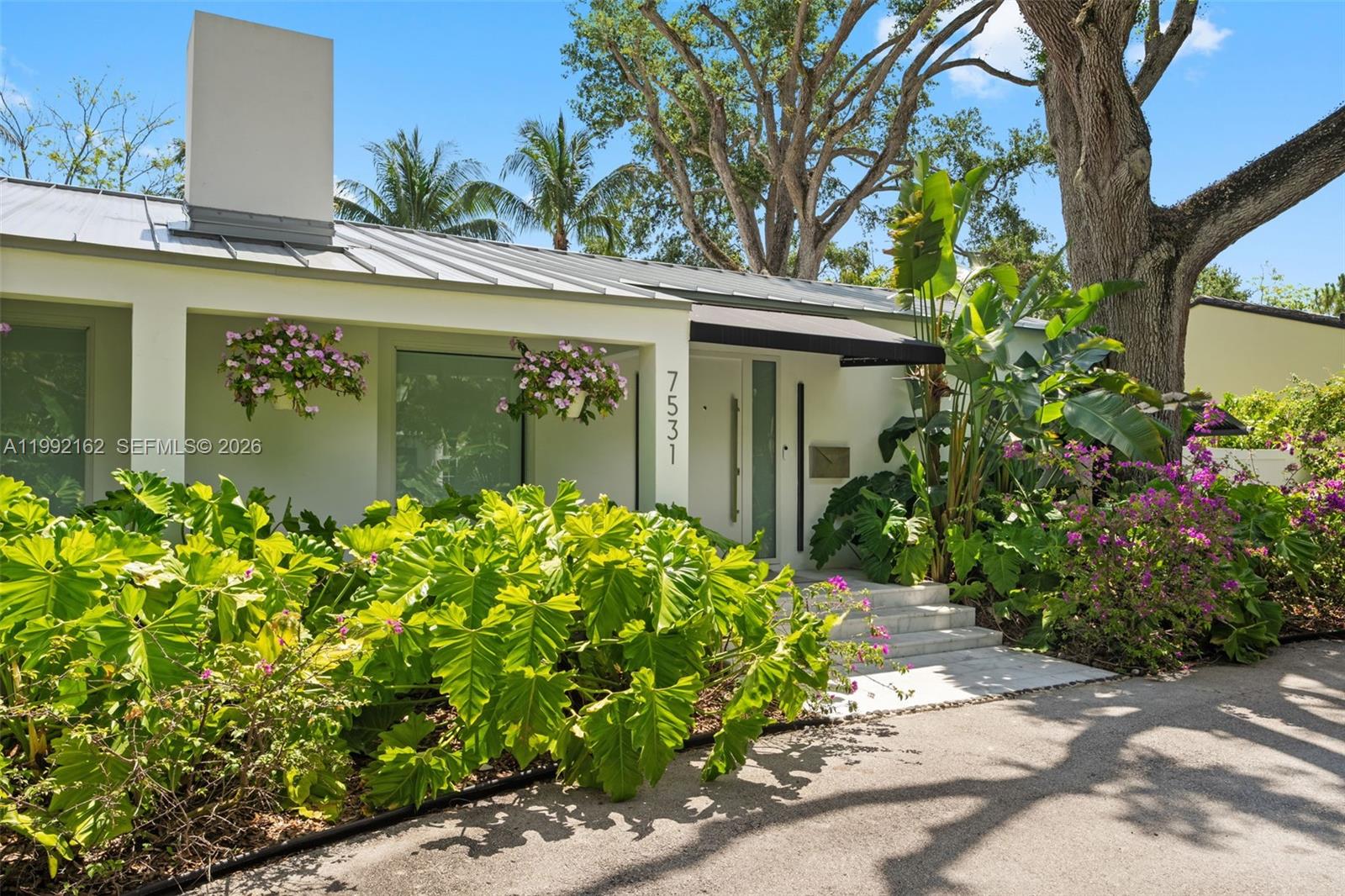 7531 Southwest 52nd Court Miami, FL 33143 - Photo 26 of 56 a front view of a house with a yard and a garden