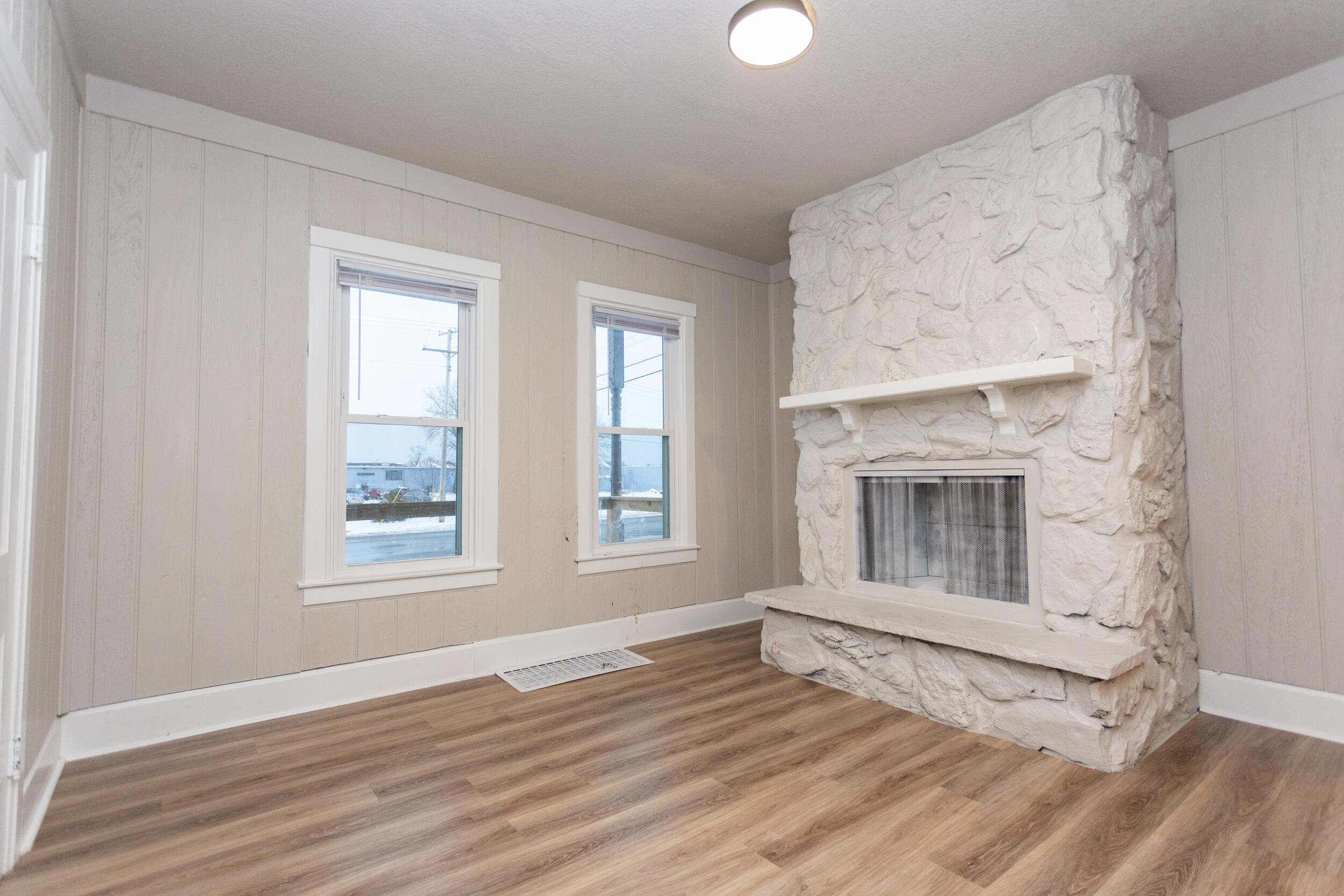 1602 Kentucky Street, Unit 1 Michigan City, IN 46360 - Photo 2 of 13 an empty room with wooden floor cabinet and windows