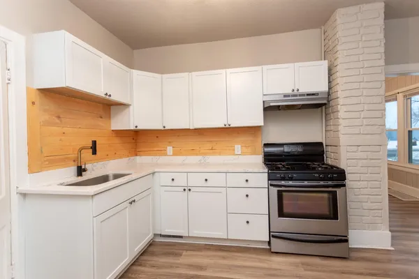 a kitchen with white cabinets and appliances