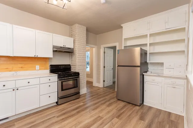 a kitchen with a refrigerator stove and white cabinets