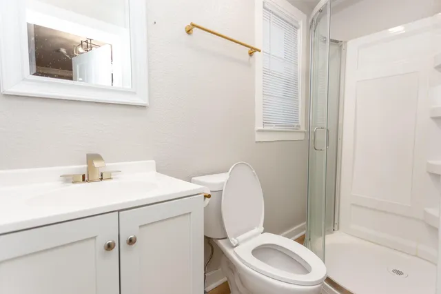 a bathroom with a toilet sink vanity and mirror