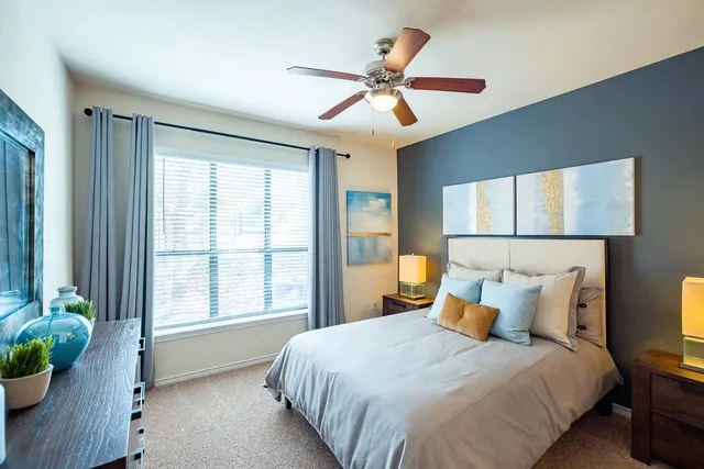 a bedroom with a large bed and a window