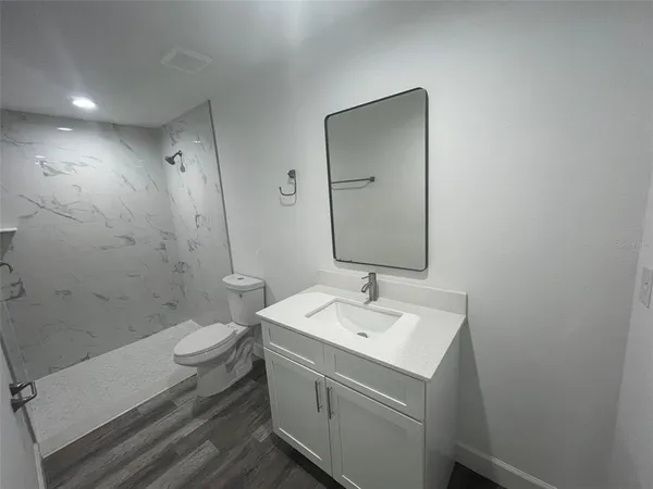 a bathroom with a sink toilet and mirror