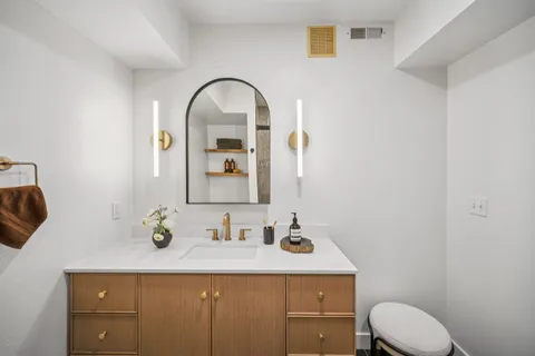a bathroom with a sink toilet and mirror