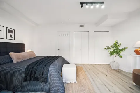 a bedroom with a bed and a potted plant