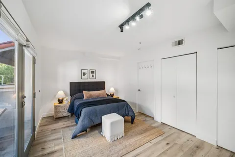 a bedroom with a bed and wooden floor