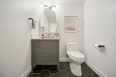 a bathroom with a toilet sink and mirror