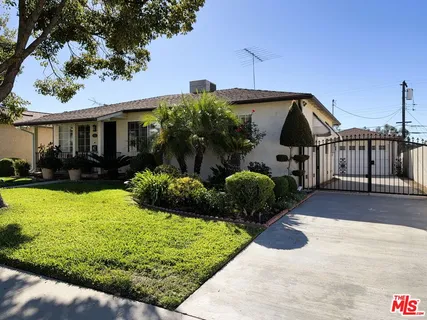 a view of a house with a yard and potted plants