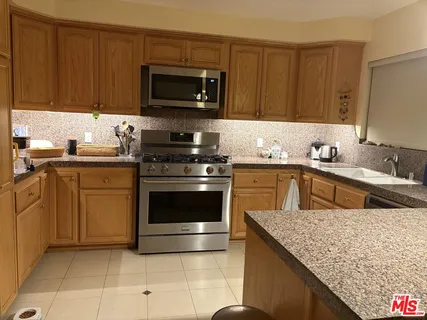 a kitchen with stainless steel appliances granite countertop a sink stove and cabinets