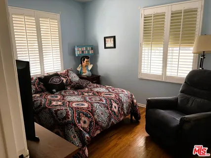 a bedroom with a bed and painting on the wall