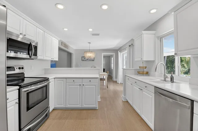 a kitchen with white cabinets stainless steel appliances and sink