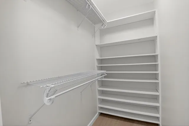 a view of walk in closet with empty racks
