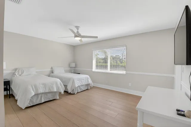 a spacious bedroom with two beds and a window