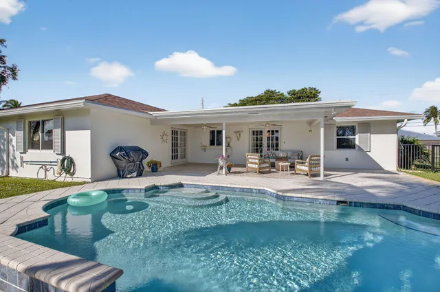 a view of a house with backyard and swimming pool
