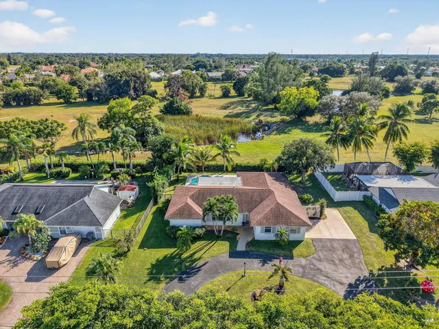 an aerial view of residential houses with outdoor space and swimming pool