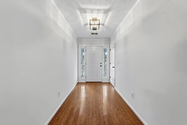 a view of a hallway with wooden floor