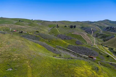 a view of a lush green hillside and houses