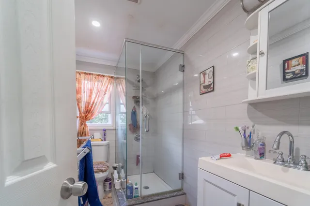 a bathroom with a shower sink vanity and mirror
