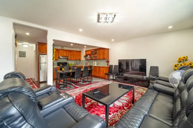a living room with furniture a flat screen tv and kitchen view