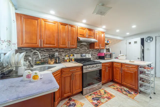 a kitchen with stainless steel appliances granite countertop a sink stove and cabinets