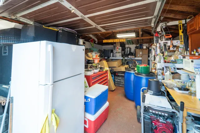 a utility room with stainless steel appliances and refrigerator