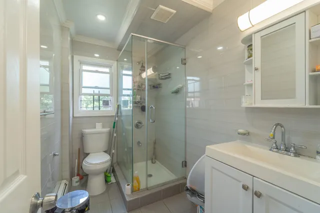 a bathroom with a shower sink vanity mirror and toilet