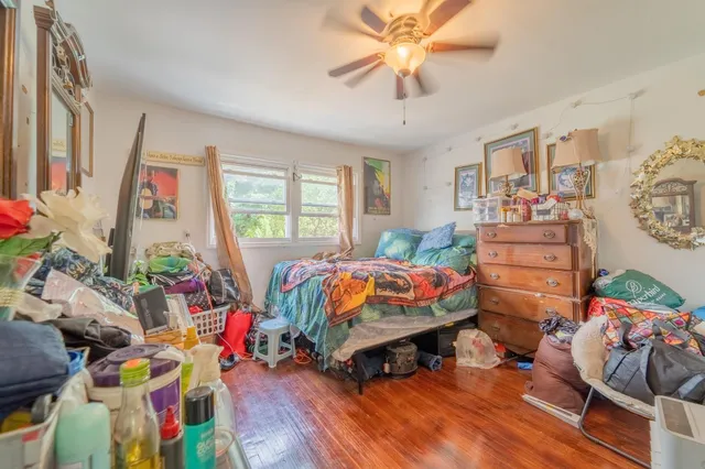 a bedroom with bed and a wooden floor
