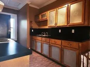 a kitchen with stainless steel appliances granite countertop a sink a stove cabinets and a wooden floor