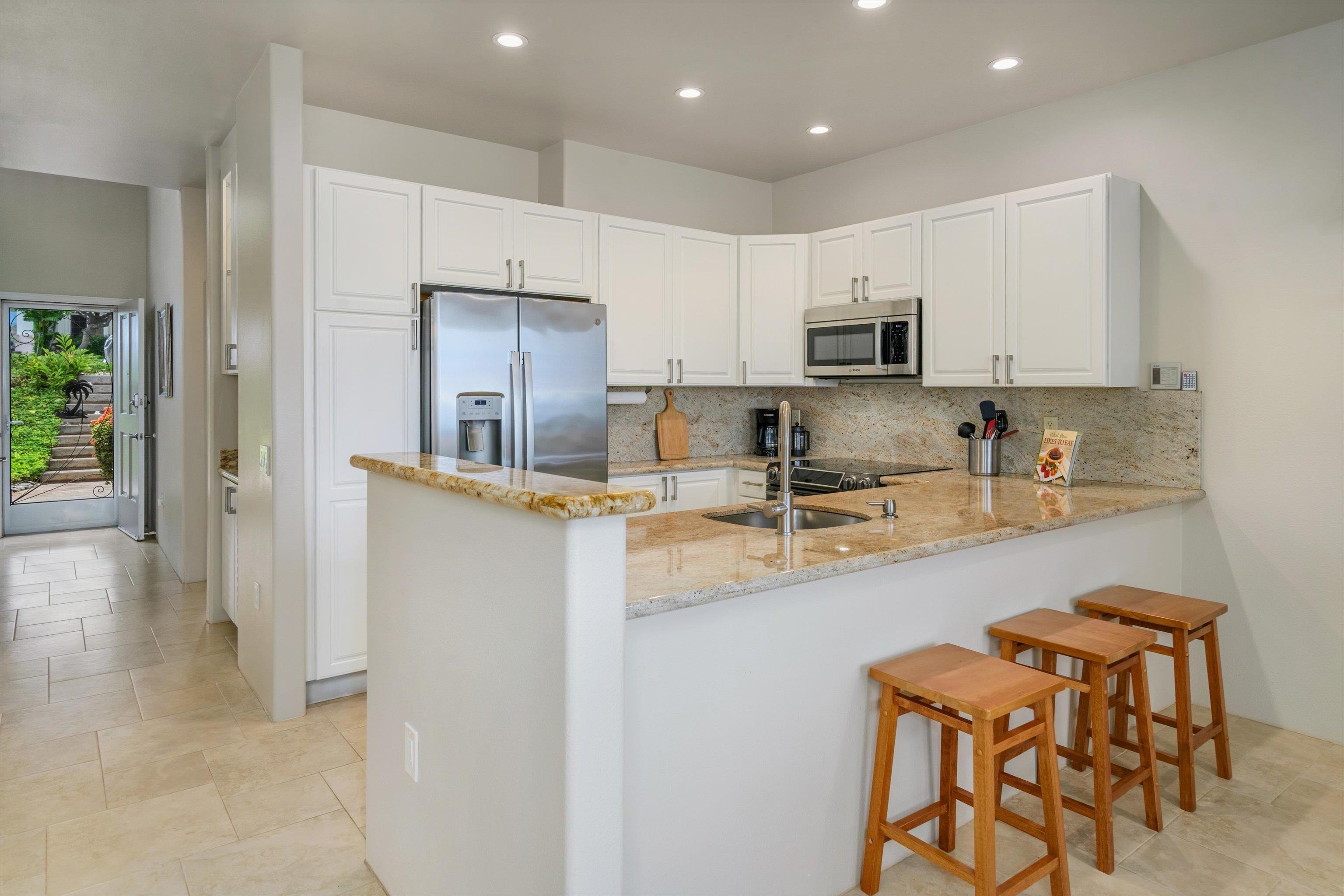 3950 Kalai Waa Street, Unit R 103 Kihei, HI 96753 - Photo 22 of 50 a kitchen with stainless steel appliances granite countertop a refrigerator and a stove top oven