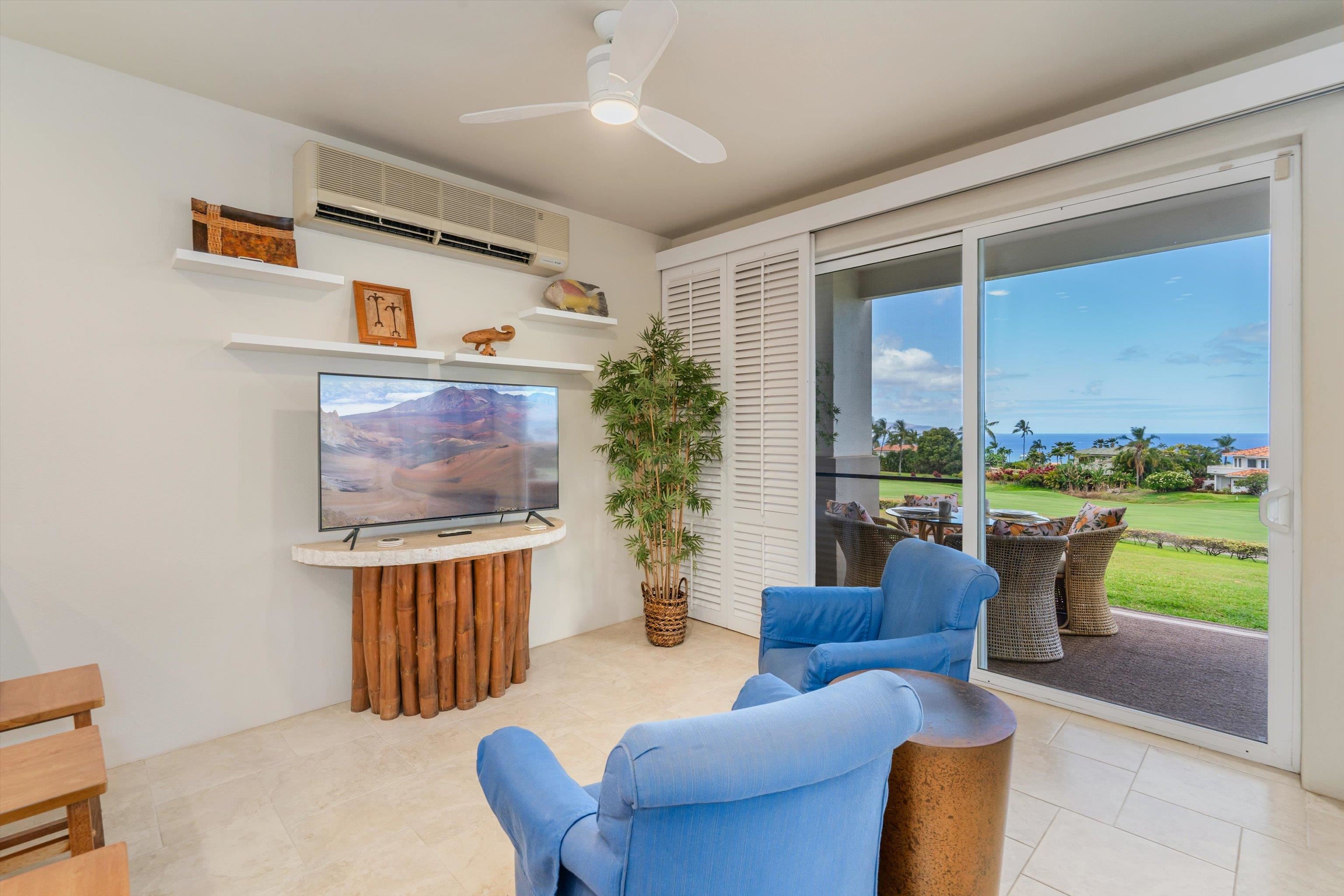 3950 Kalai Waa Street, Unit R 103 Kihei, HI 96753 - Photo 25 of 50 a living room with furniture a flat screen tv and a floor to ceiling window