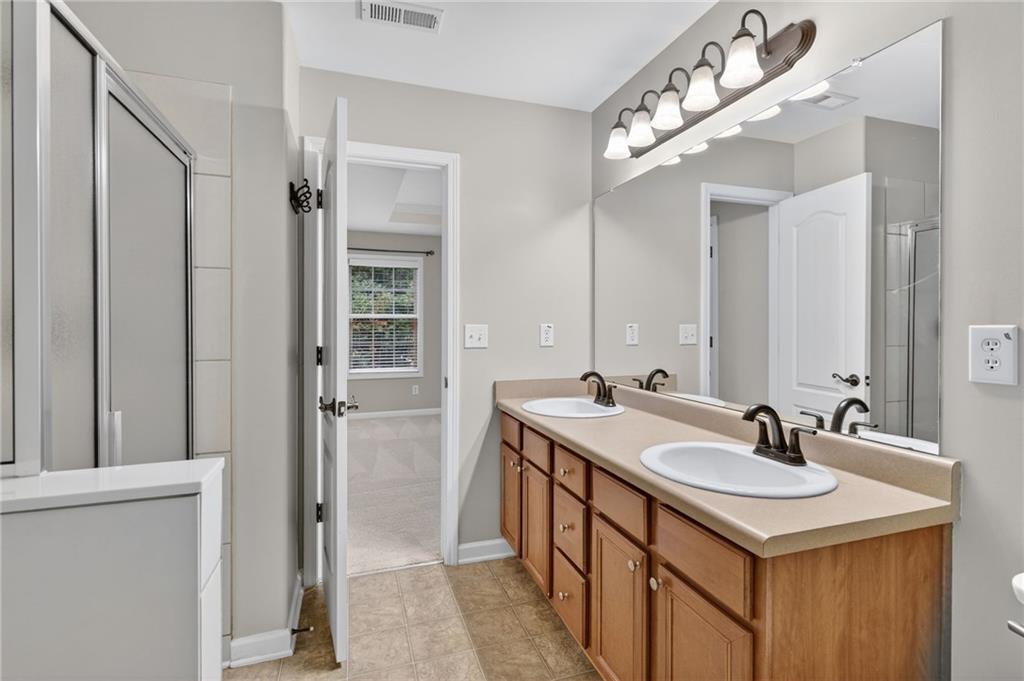 1186 Lake Point Way Suwanee, GA 30024 - Photo 22 of 35 a bathroom with a sink and a mirror