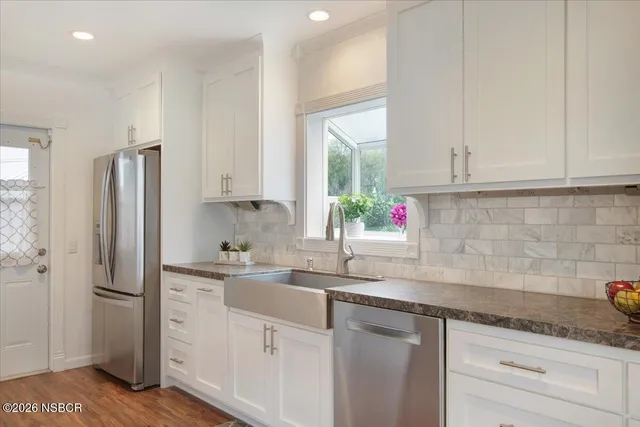 a kitchen with stainless steel appliances white cabinets and a sink