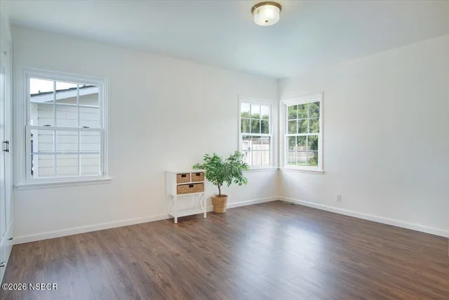 a view of a room that has wooden floor and window in it