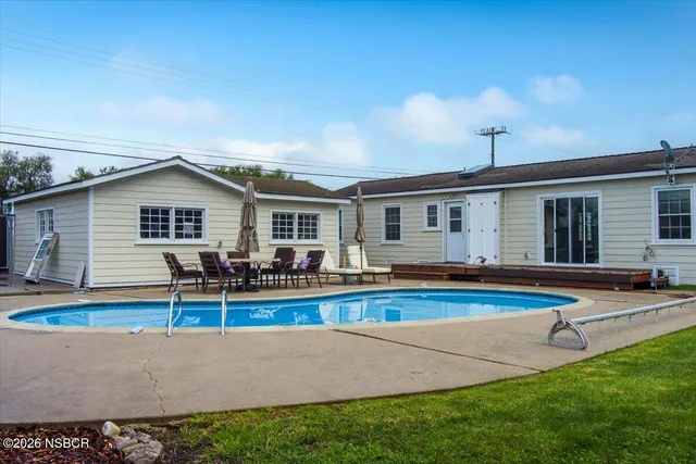 a view of a house with swimming pool and sitting area